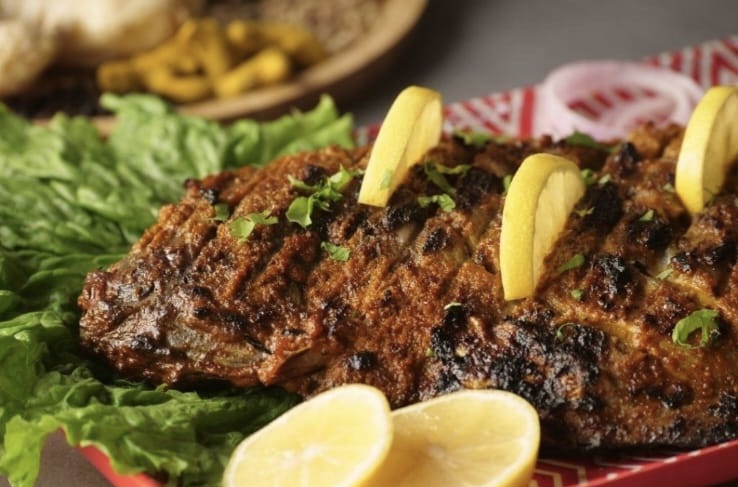 Tandoori fish on lettuce with lemon slices